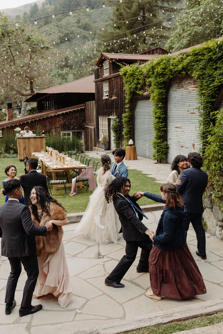 a small group of people dances on the patio of the village Big Sur during an intimate wedding reception