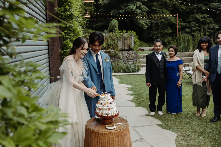 a newlywed couple cuts the cake at their wedding reception at the village Big Sur