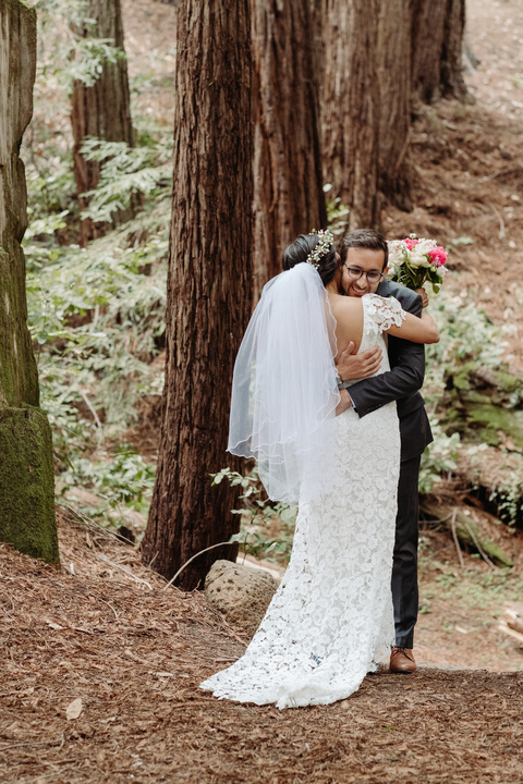 a newlywed couple hugs under the redwoods