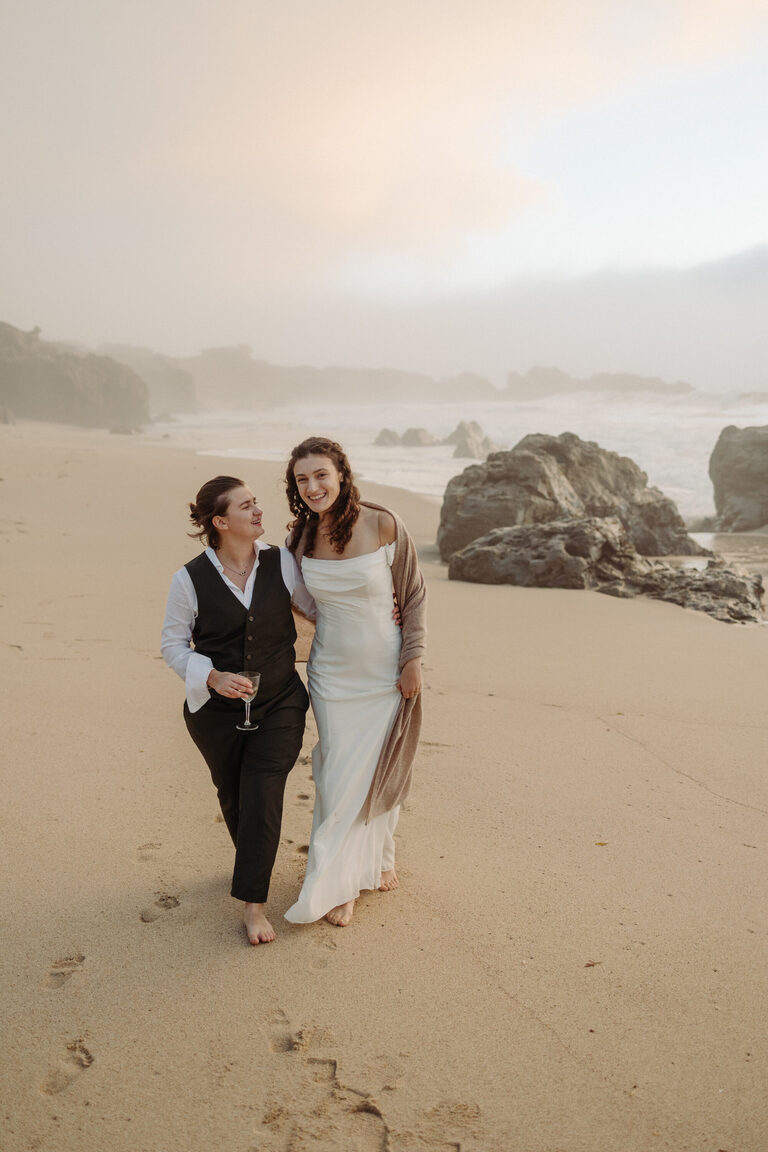a couple walks the beach at sunset in Big Sur on the day they eloped