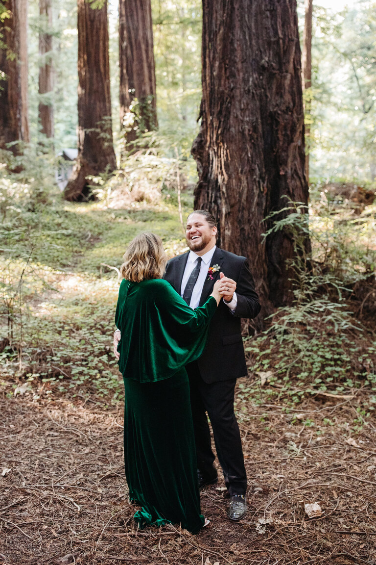 a couple takes their first dance under the redwoods