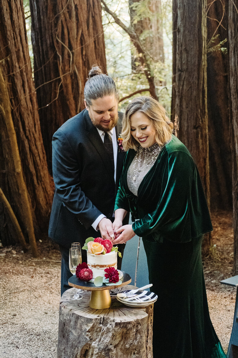 a couple cuts their cake after their redwood forest elopement ceremony