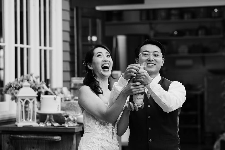 couple opening champagne on their wedding day/ santa cruz documentary wedding photographer