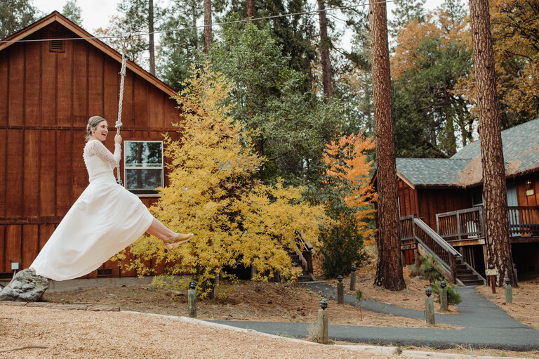 a bride ziplines into her first look with her fiancé on their wedding day at Evergreen Lodge Yosemite